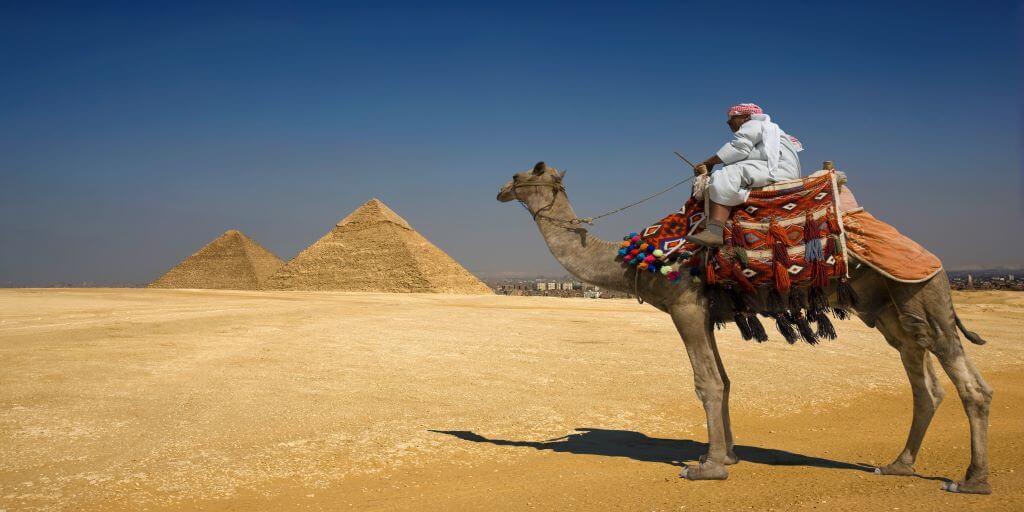 A man riding a camel in the desert to remind us of the desert where Abraham entered into covenant with God.