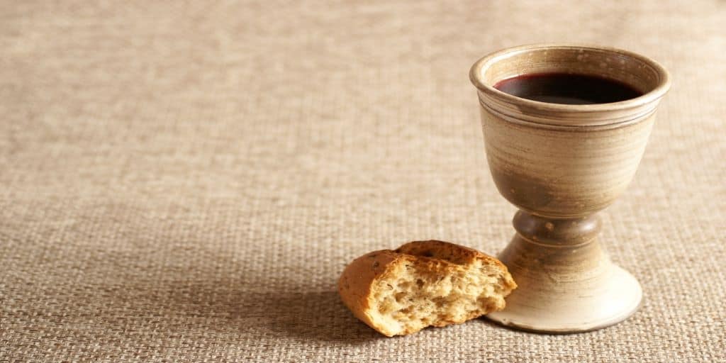 A broken loaf of bread next to an earthenware goblet of wine to remind us of the new covenant in Christ.